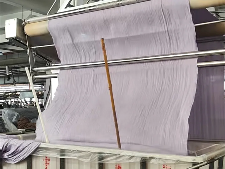 Purple fabric running through production equipment at Yuxin factory